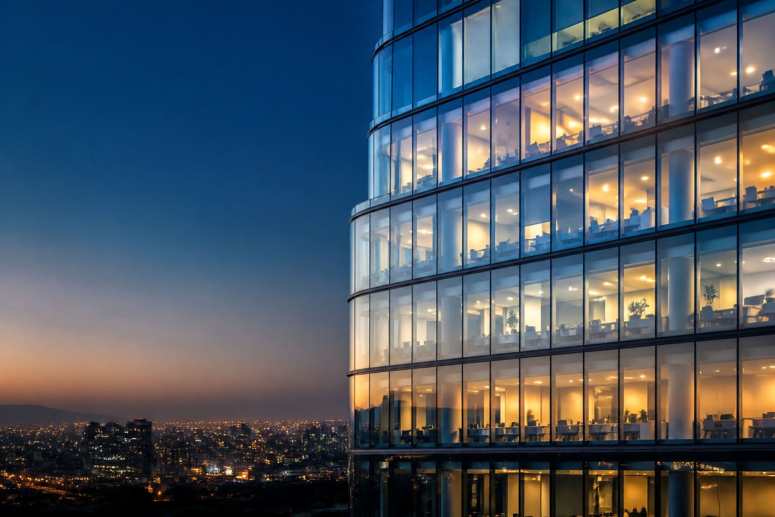Edificio corporativo iluminado al anochecer sobre una ciudad.